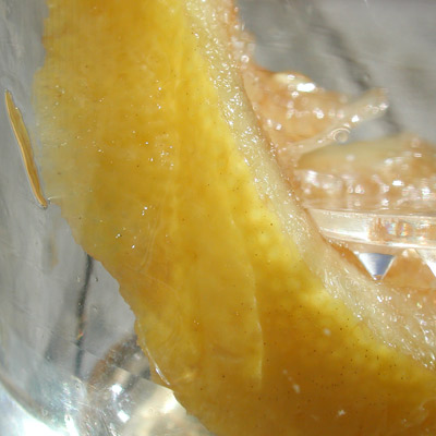 Manon duwt voorzichtig het partje citroen in het bubbelige water naar beneden 